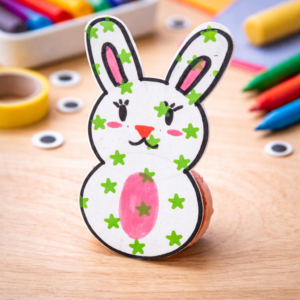 Mini tentetieso infantil hecho con cartulina y tapón reciclado para aprender la primera ley de Newton en un taller de ciencia con arte.